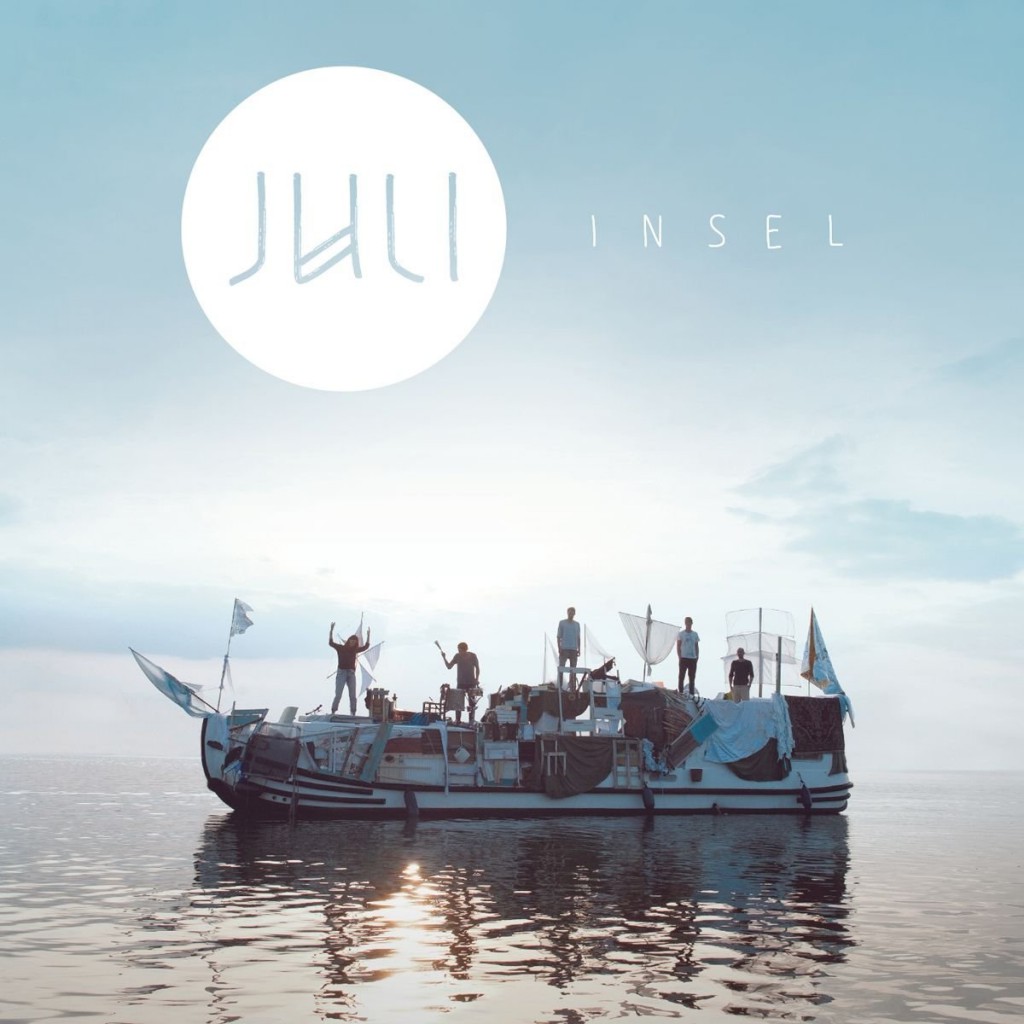 Cover des Albums „Insel“ von Juli: Boot mit Menschen an Bord auf ruhigem Wasser unter hellem Himmel, oben das Juli-Logo